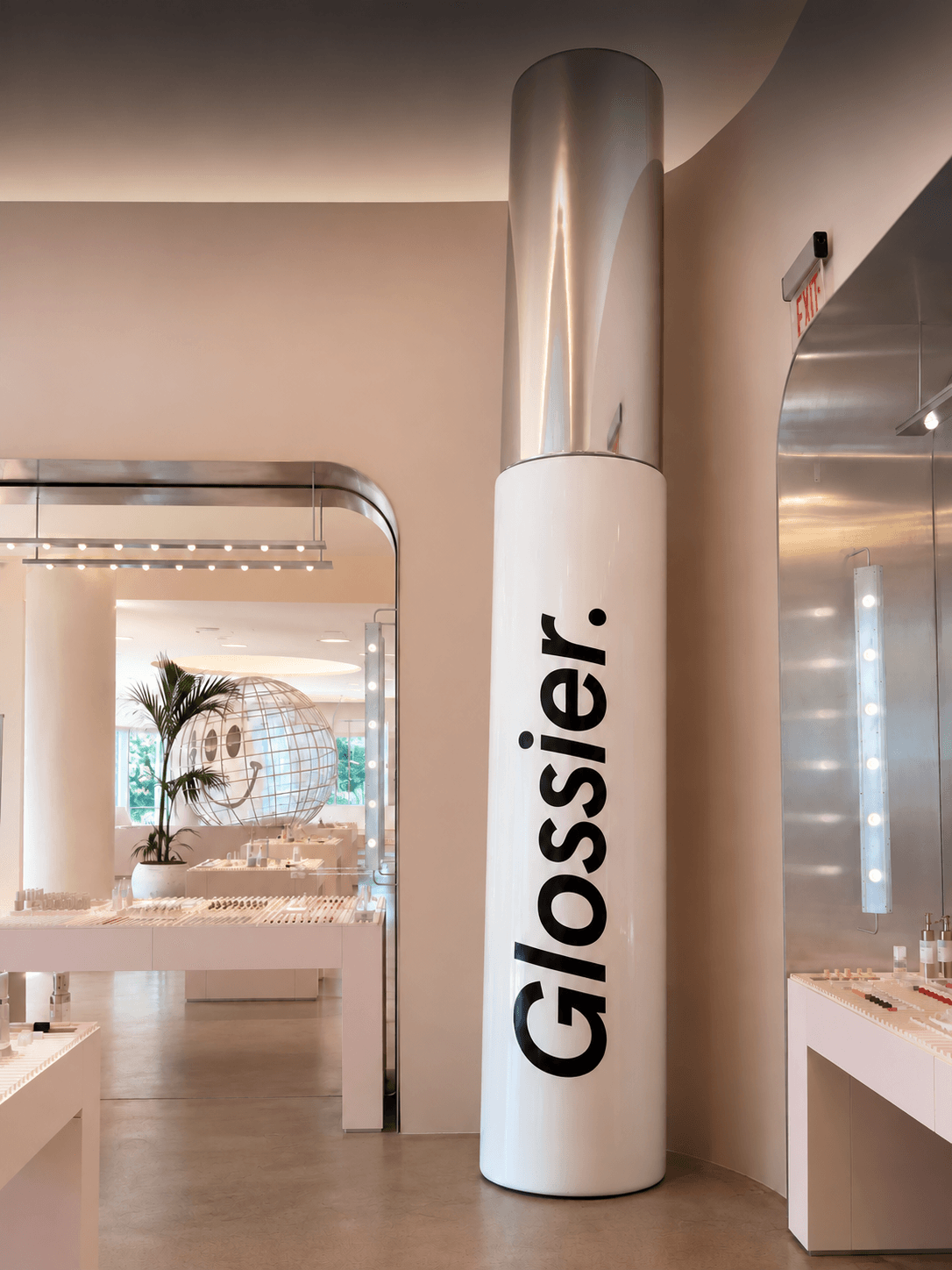 Giant white Glossier cosmetic tube replica with a gold cap