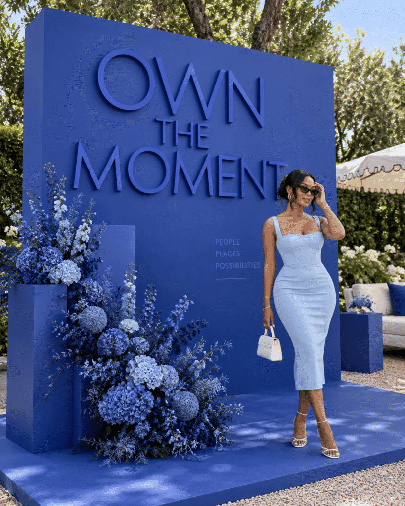 Blue OWN THE MOMENT backdrop with raised lettering and dimensional panels