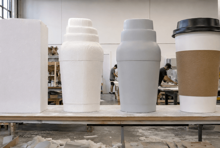 Unfinished white bottle and coffee cup replica forms in the workshop